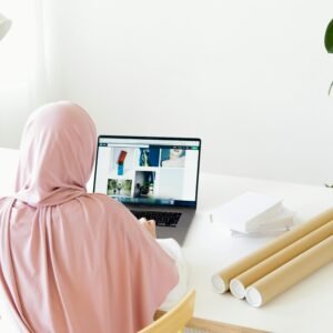 Woman in Pink Hijab Sitting in Front of Gray Laptop