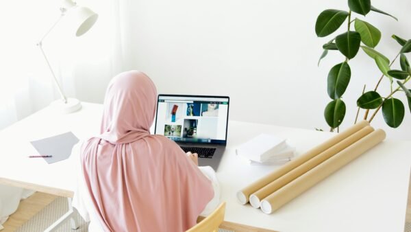 Woman in Pink Hijab Sitting in Front of Gray Laptop